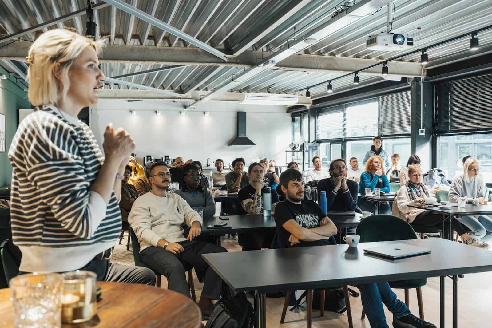 Password Management, A dynamic speaker engaging a diverse audience in a modern workshop setting.