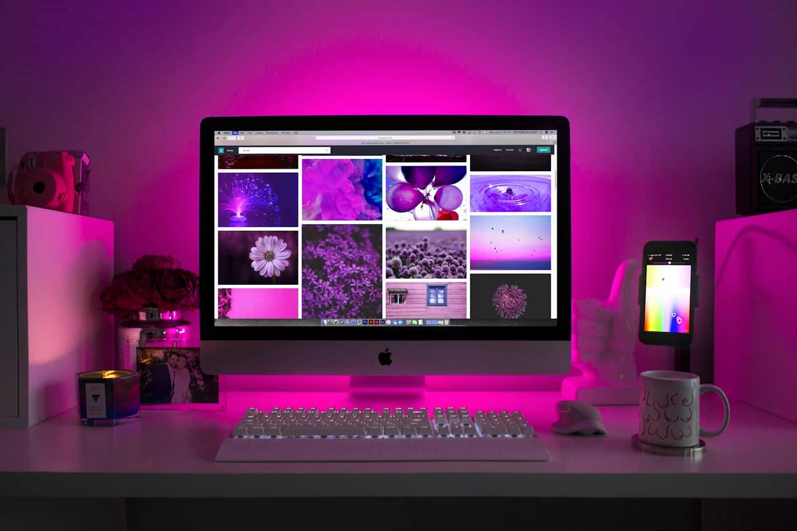 Elementor Page builder, website, development, design, drag n drop, wordpress, Modern desk setup with neon lighting and a desktop computer displaying colorful images.
