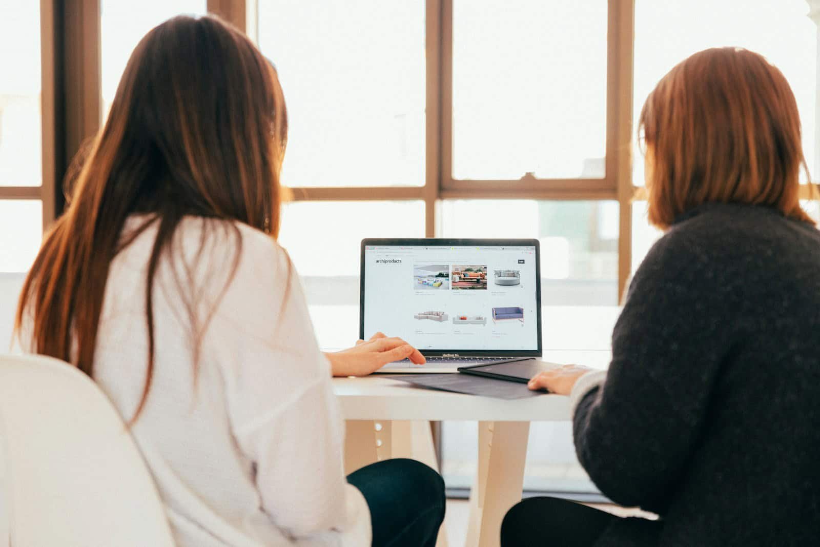Maximizing Your Online Presence with a Digital Marketing Agency, two women talking while looking at laptop computer