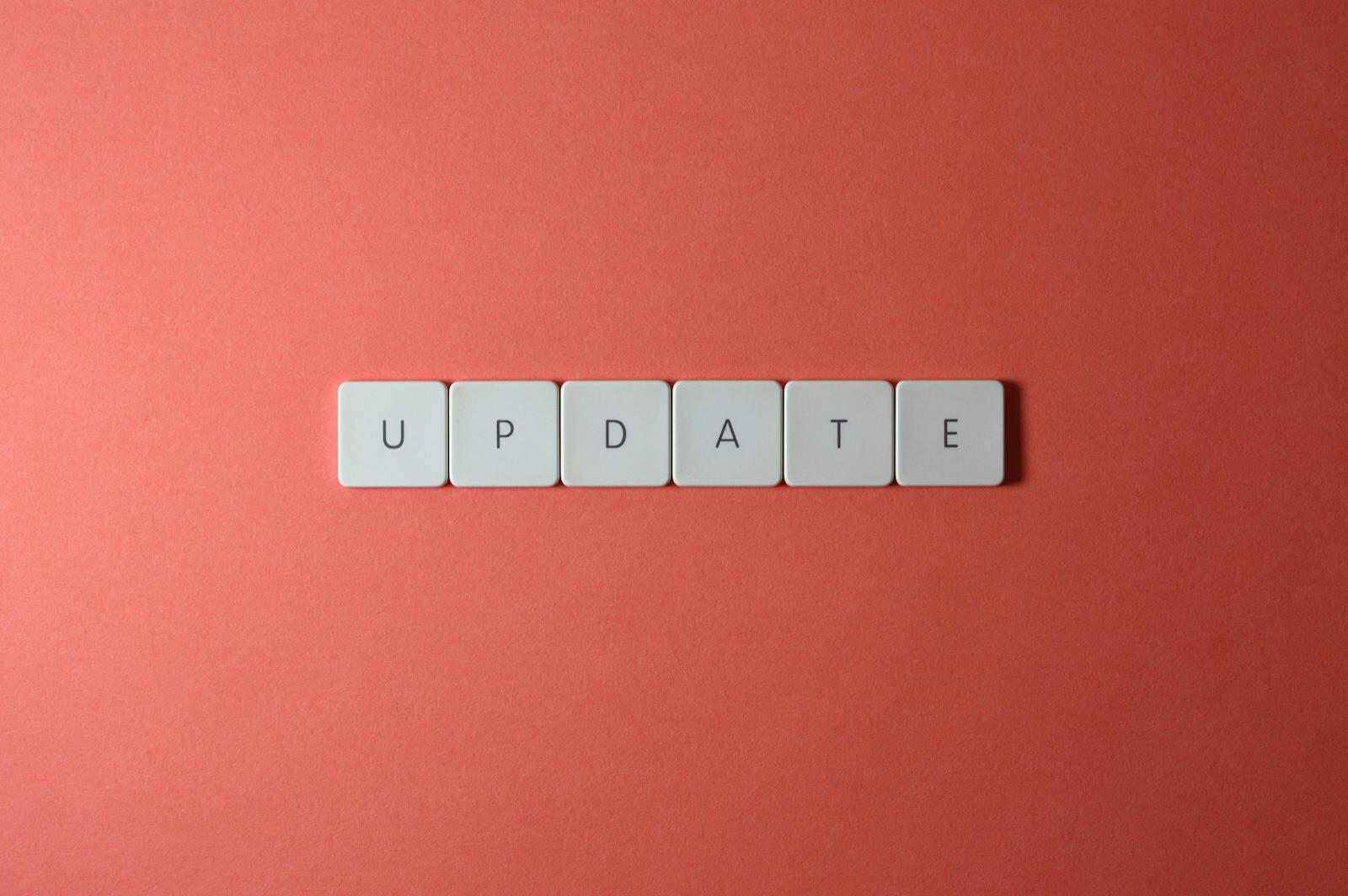 software update, Keyboard keys arranged to spell 'update' on a vibrant red background, ideal for conveying tech concepts.