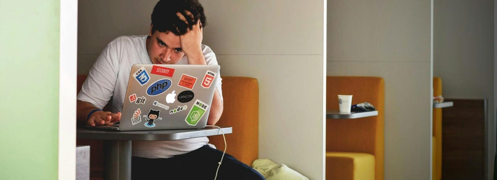 Man showing stress and frustration while working remotely on a laptop indoors. Entrepreneurship, TheDip, BusinessStrategy, Mindset, SethGodin