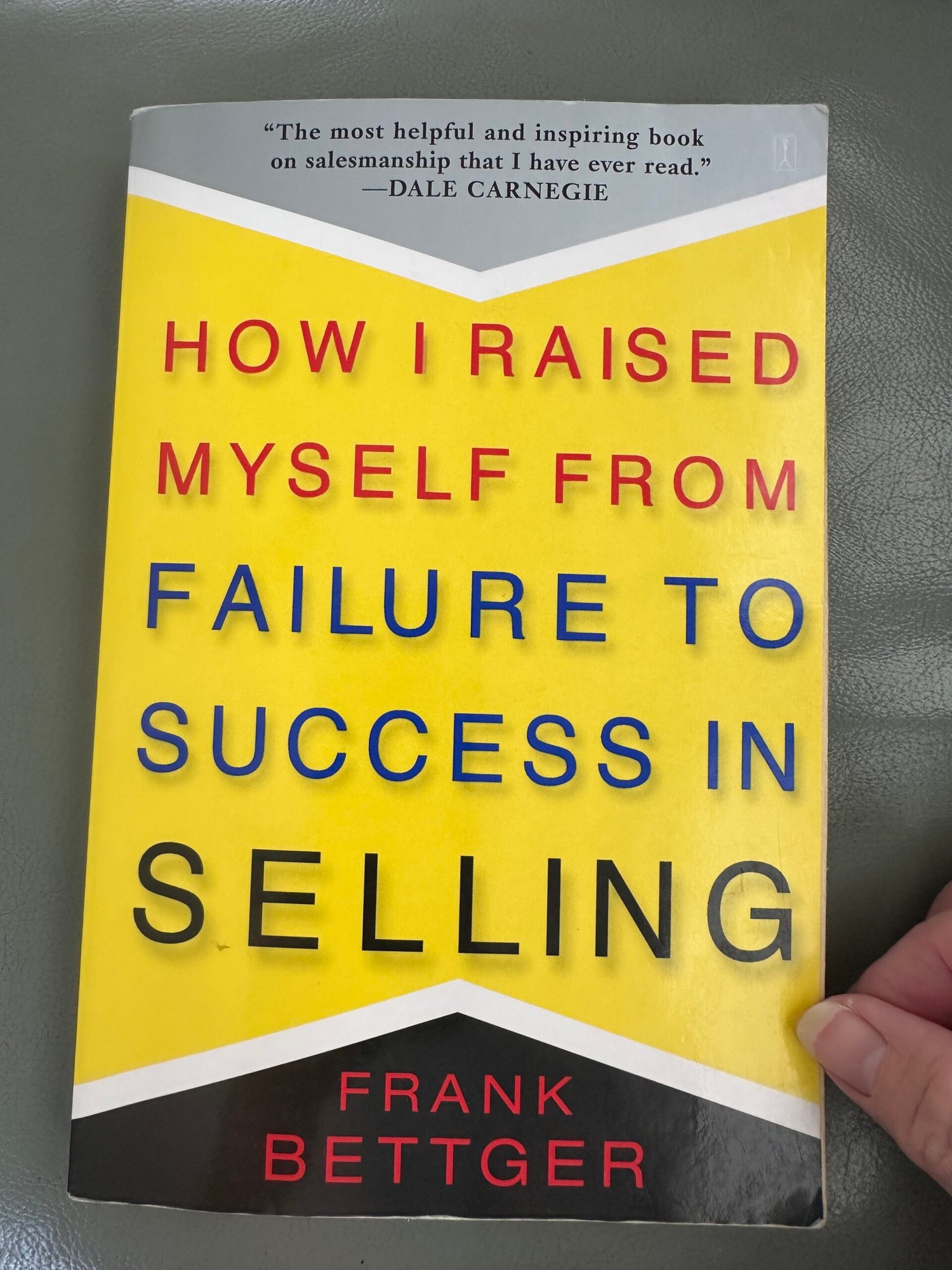 How I Raised Myself From Failure to Success in Selling book laying on an armrest.