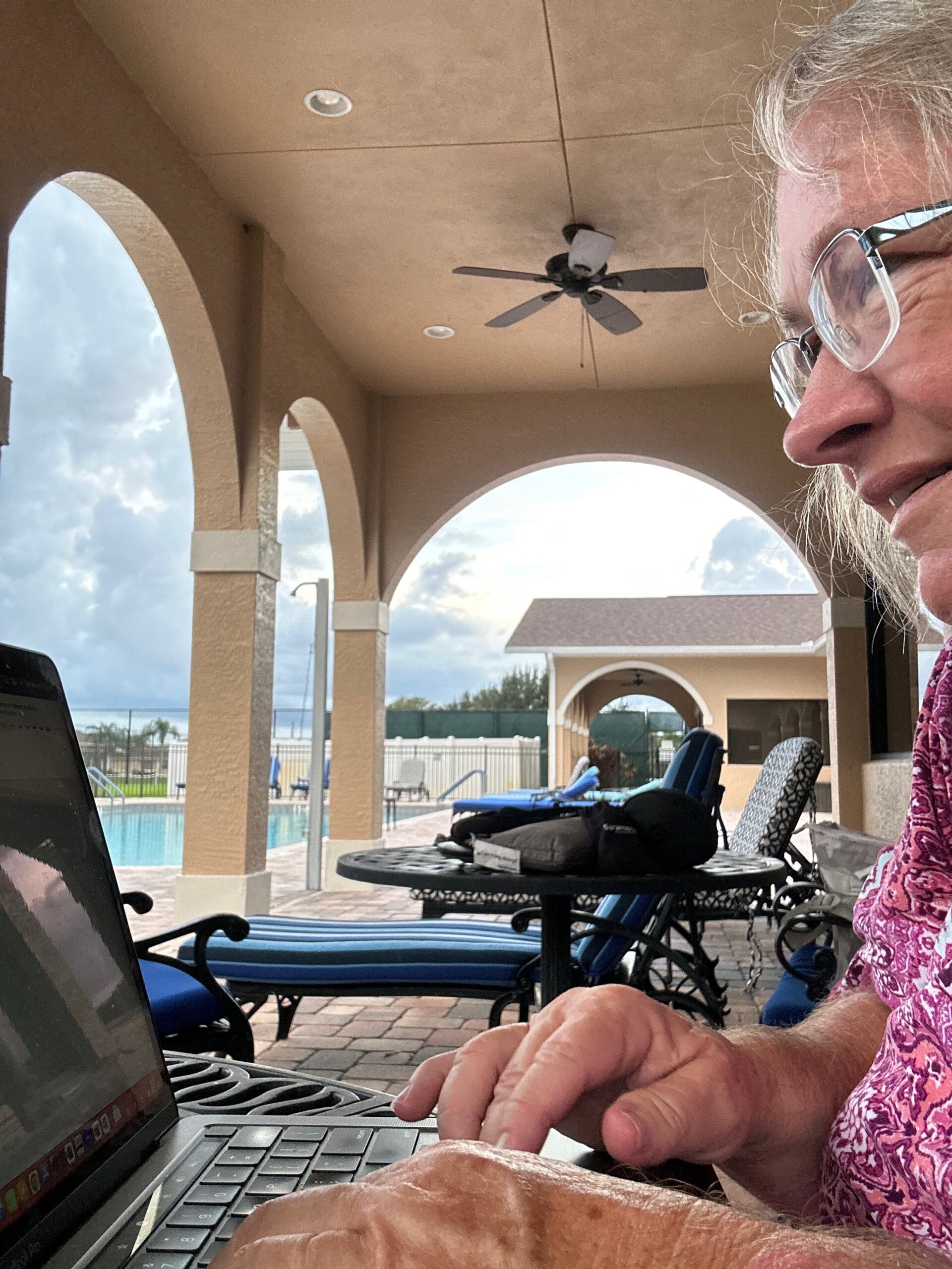 Amy working on Mac Book outdoors showing the remote laptop life