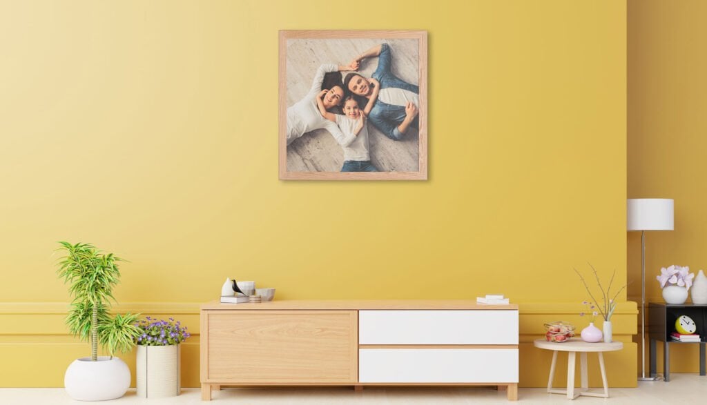 The Corwall Frame 2 Family Photographer A living room with yellow walls and a picture with an intricate frame design hanging on the wall.