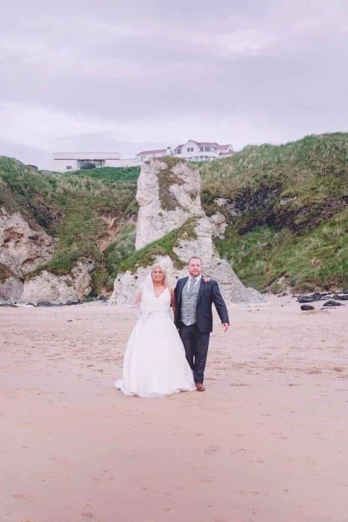 The Best Wedding venues - The Royal Court Hotel Portrush 6 Family Photographer A bride and groom walking on the beach.
