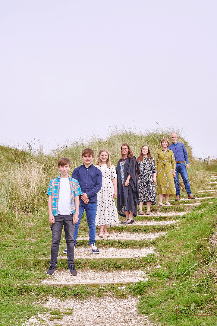 Family Photographer A group of people standing on steps in a grassy field.