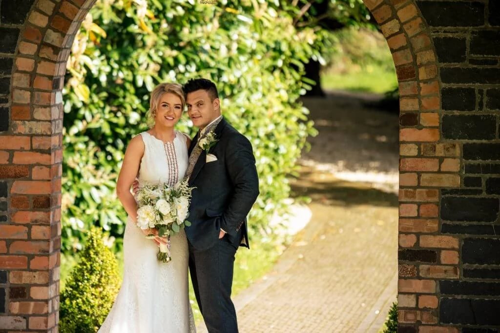 Megan & Lee 1 Family Photographer A bride and groom posing in an archway.