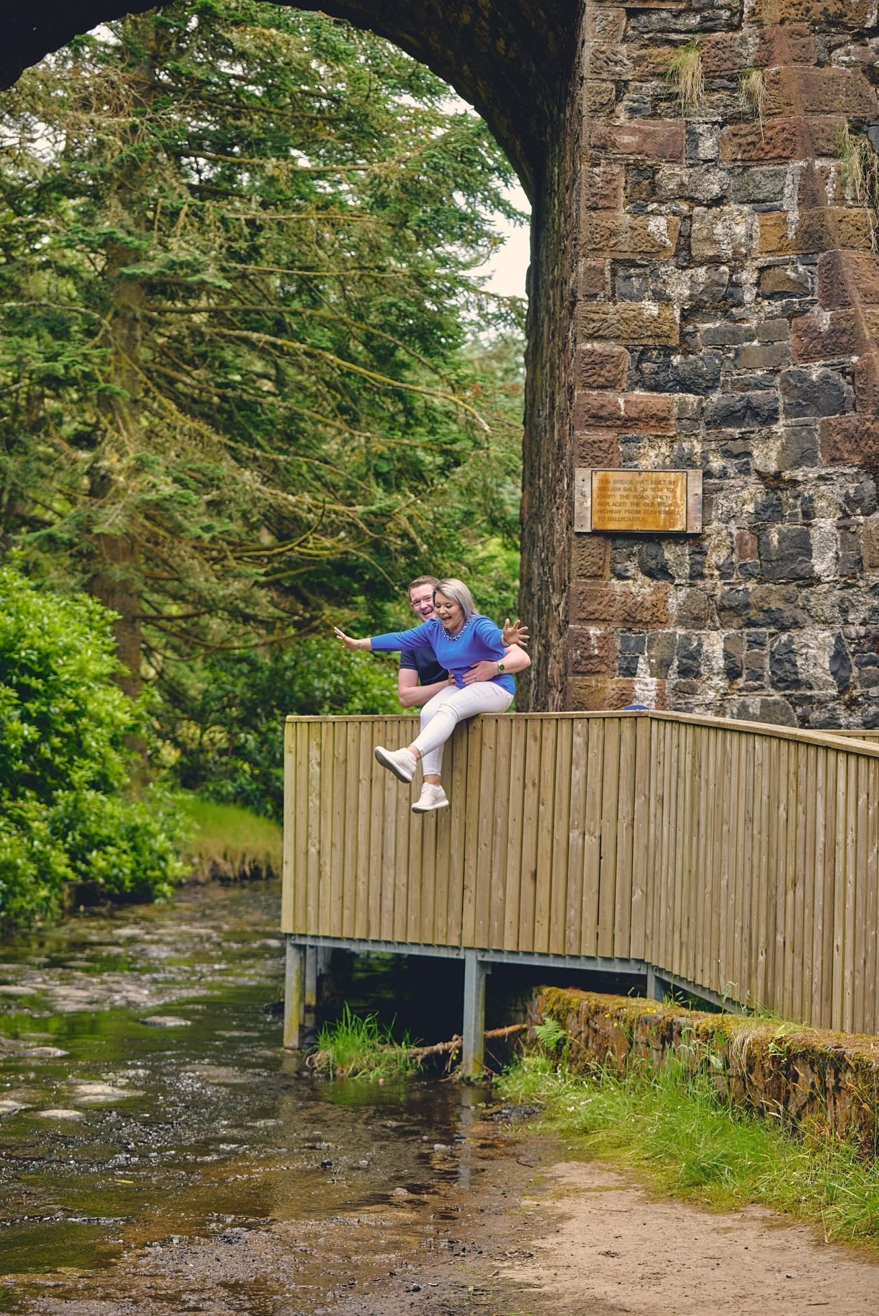 Ballycastle Engagement shoot 1 A man is standing on a wooden bridge over a stream.