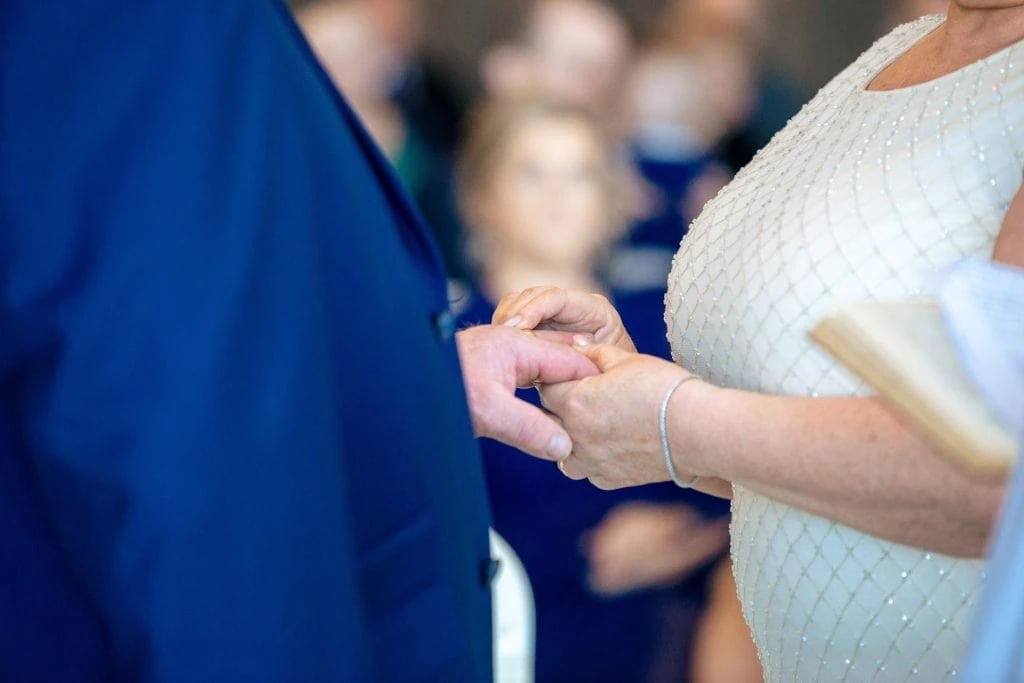 The Best Wedding venues - The Royal Court Hotel Portrush 1 Family Photographer A bride and groom exchange rings during a wedding ceremony.