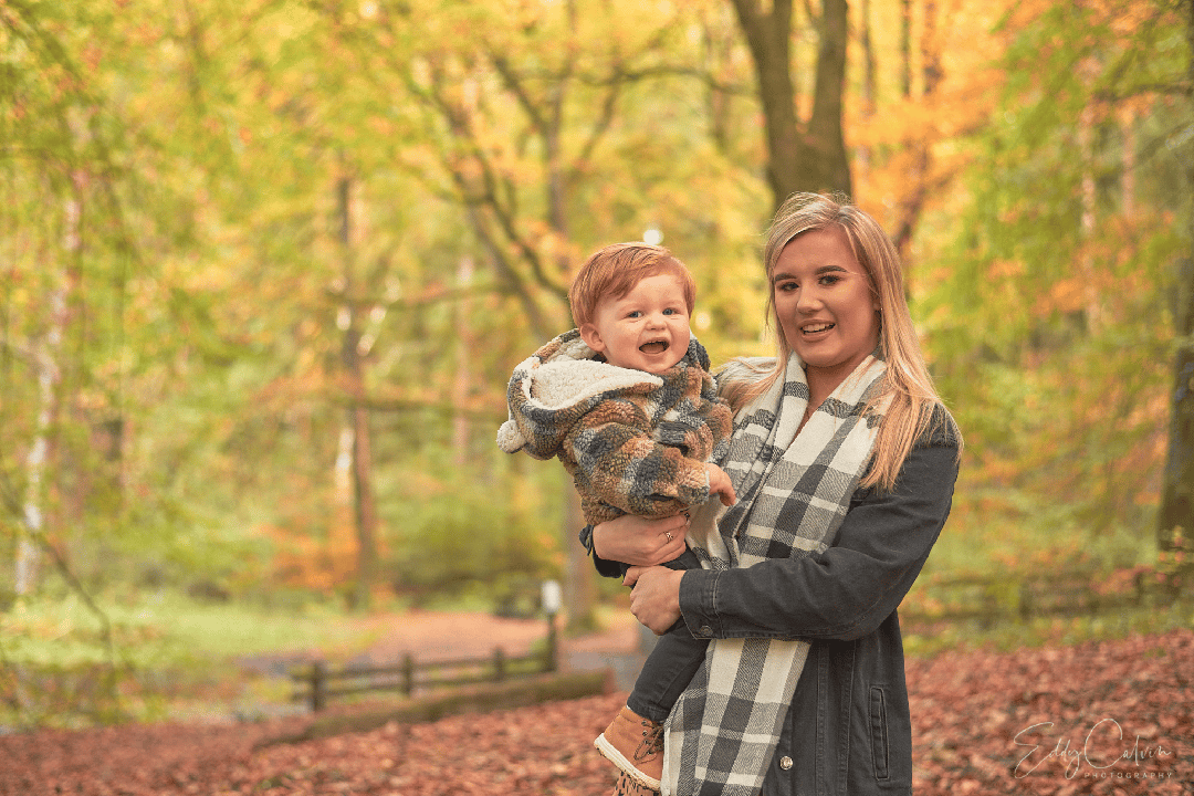 The Art of Photography: A Look into the Creative Process of a Ballymoney Photographer 2 Family Photographer A woman holding a baby in an autumn forest.