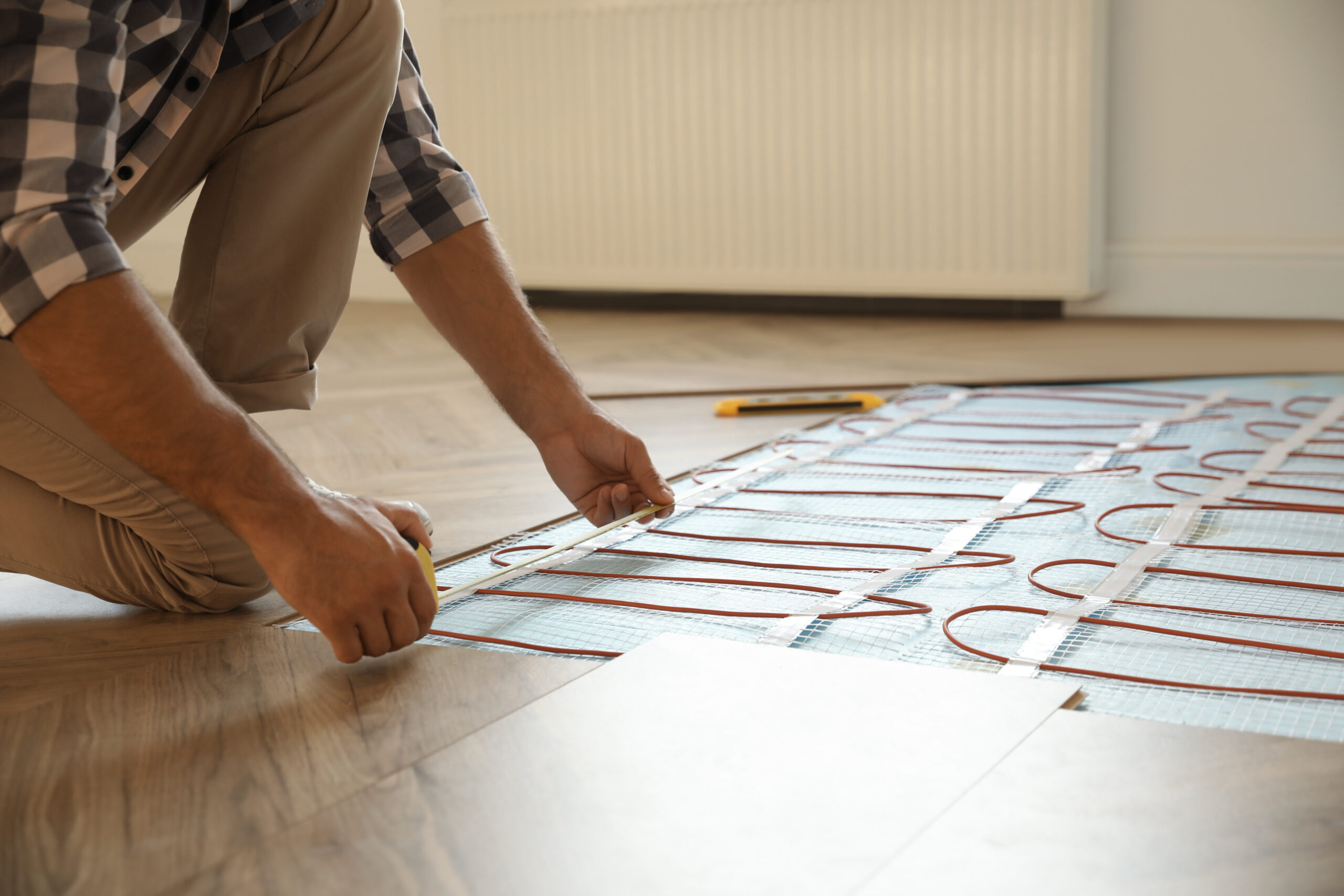 Professional worker installing Electric underfloor heating