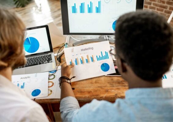 Two people reviewing their marketing guide against their actual marketing analytics