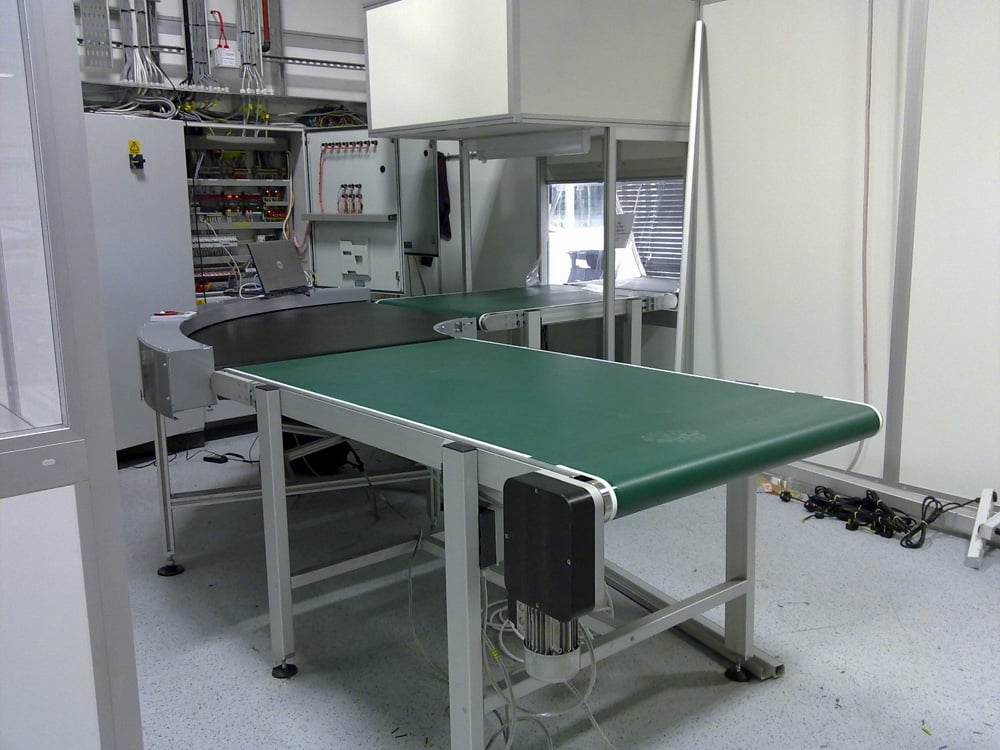Conveyor belt system lead through to a clean room environment