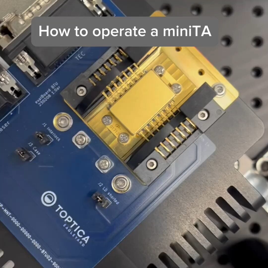 Three men stand smiling at a tech exhibition booth with a robot graphic and signage reading "Thinking Beyond" in the background.